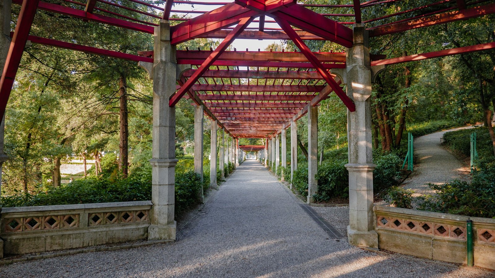 Path in a park with red geometric metal roof construction