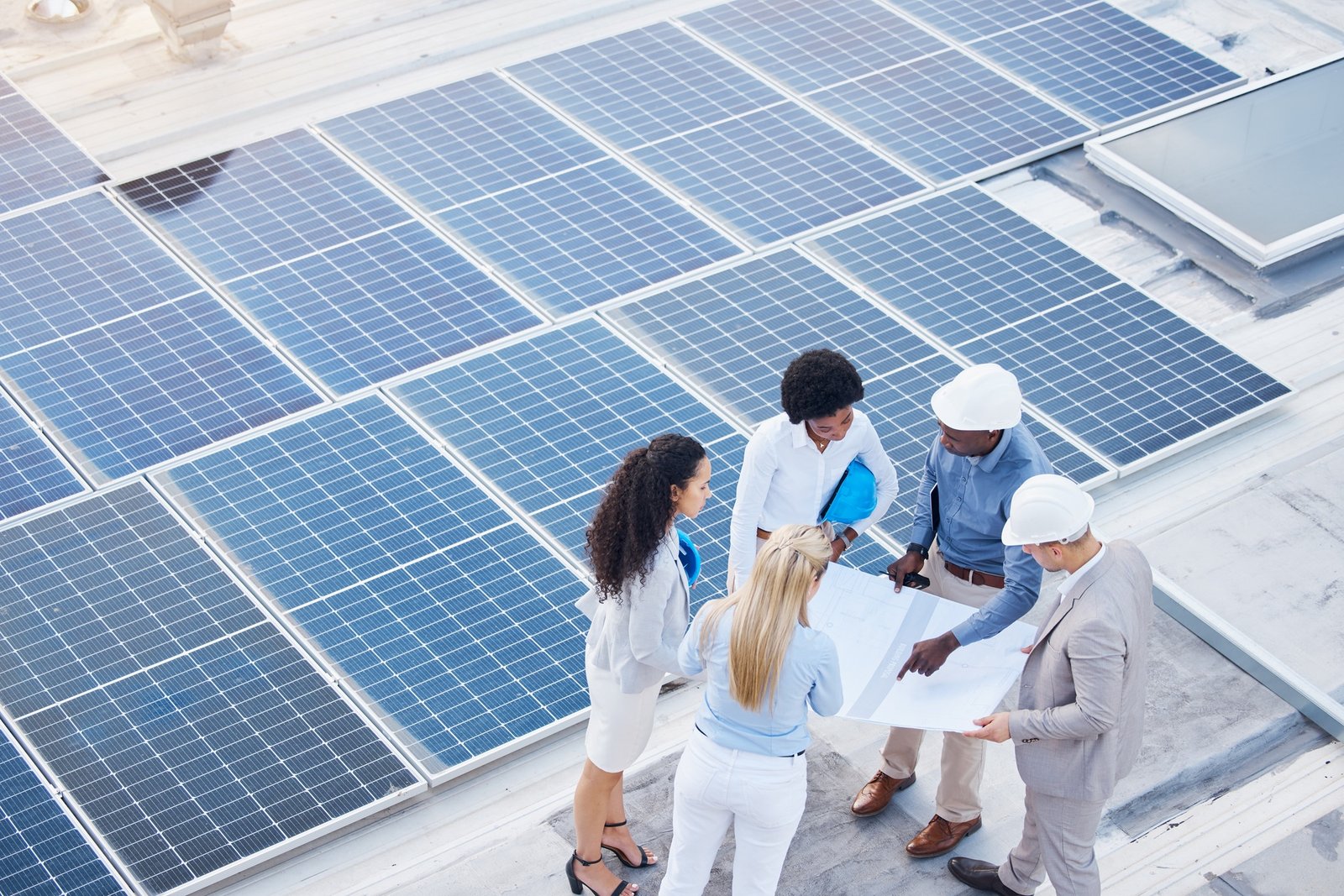 Solar energy, design or engineering team on roof by solar panels for electricity technology innovat